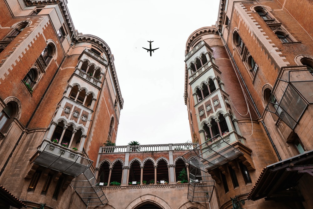 an airplane flying in the sky over a building