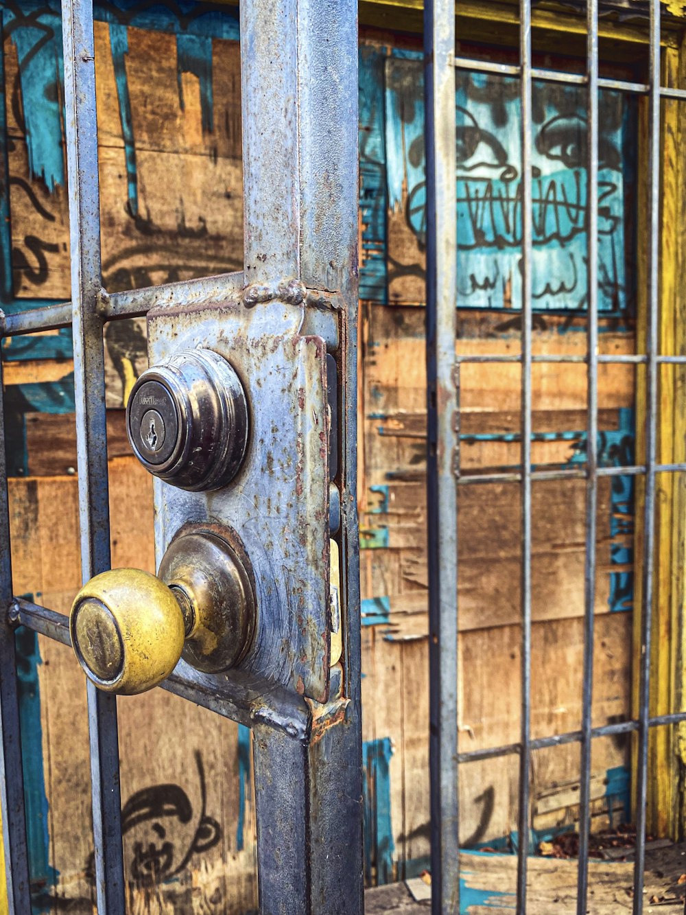 a rusted metal door with two knobs on it