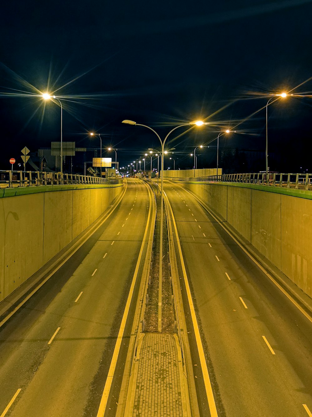 an empty highway at night with street lights
