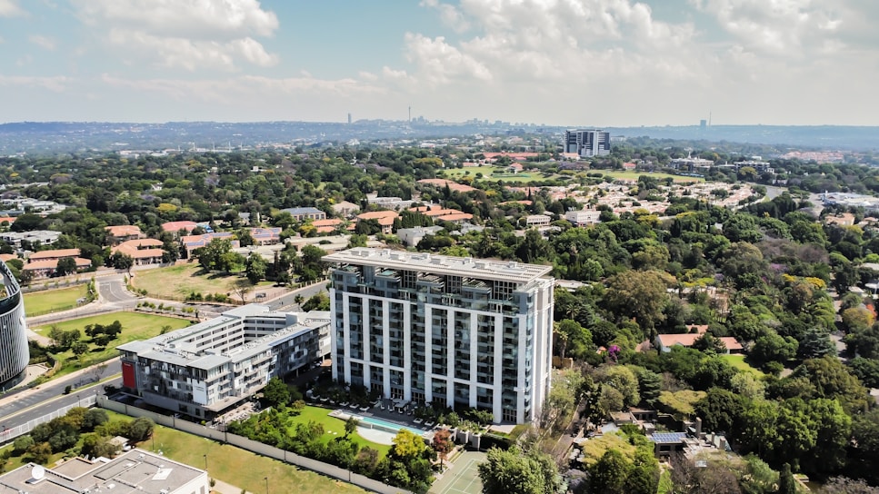 Aerial view of a modern high-rise building surrounded by greenery.