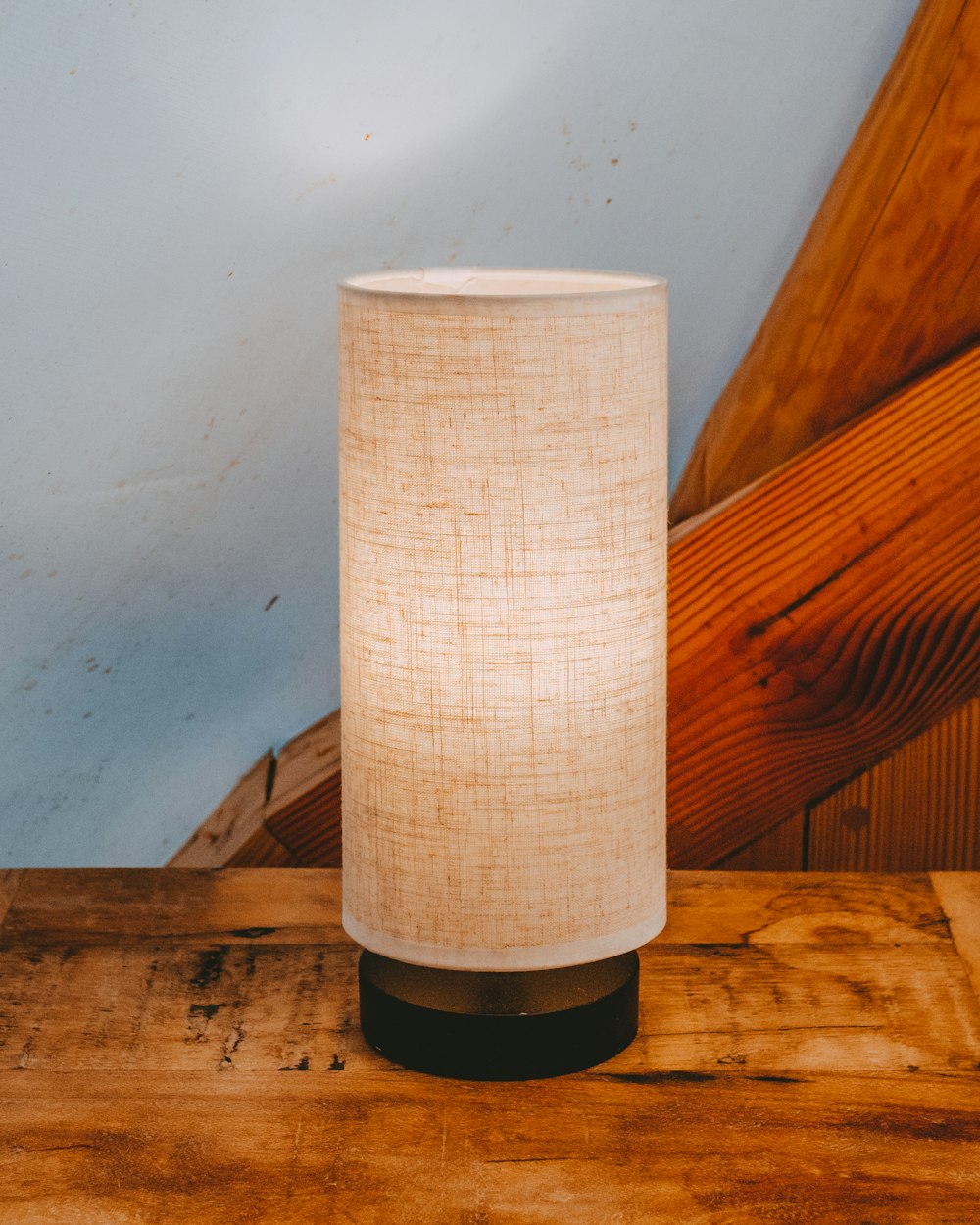 a lamp is sitting on a wooden table