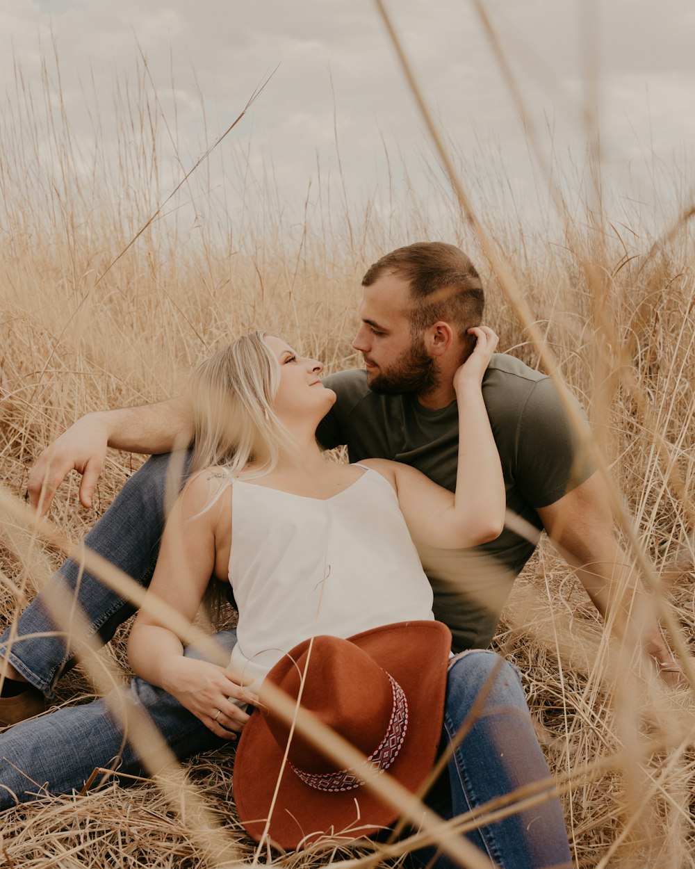 a man and a woman sitting in a field of tall grass