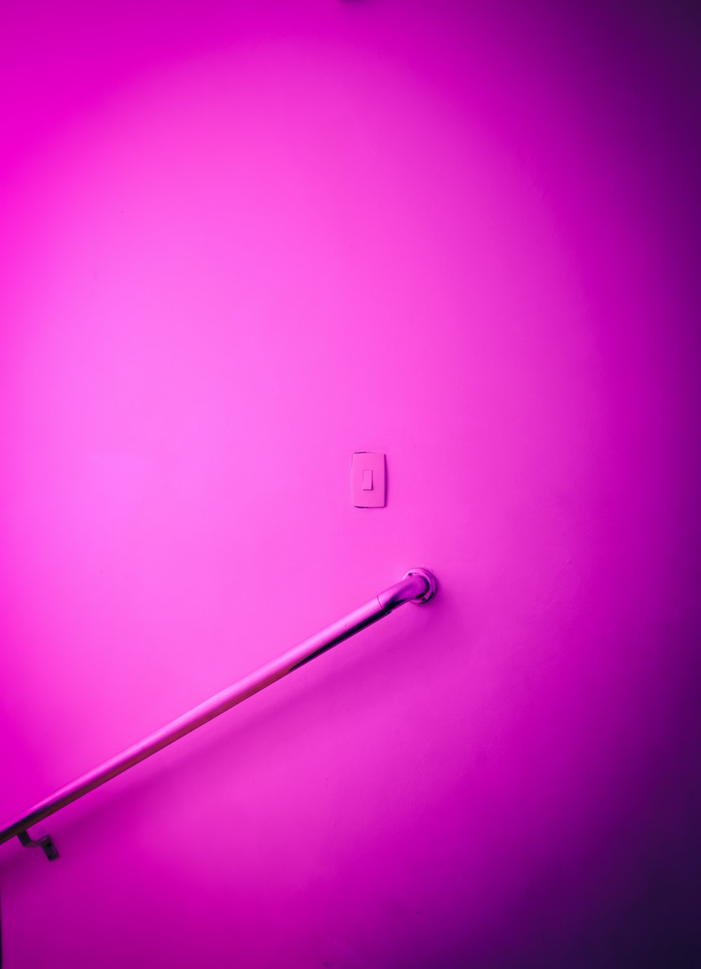 a bathroom with a toilet and a pink wall