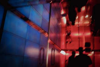 A futuristic hallway illuminated by layered neon blues and sunset peach tones from ambient tech fixtures.