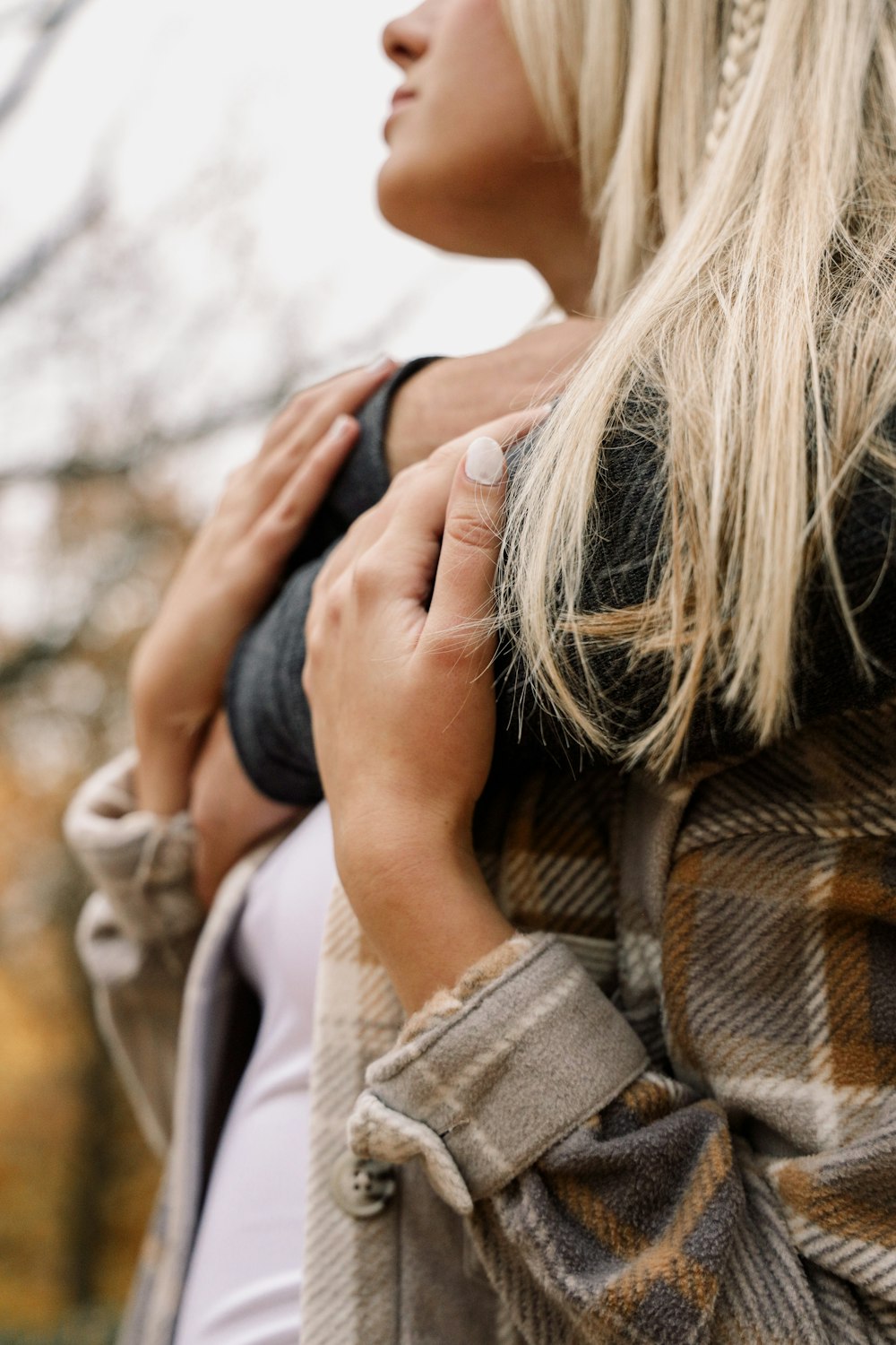 a woman with blonde hair wearing a plaid jacket