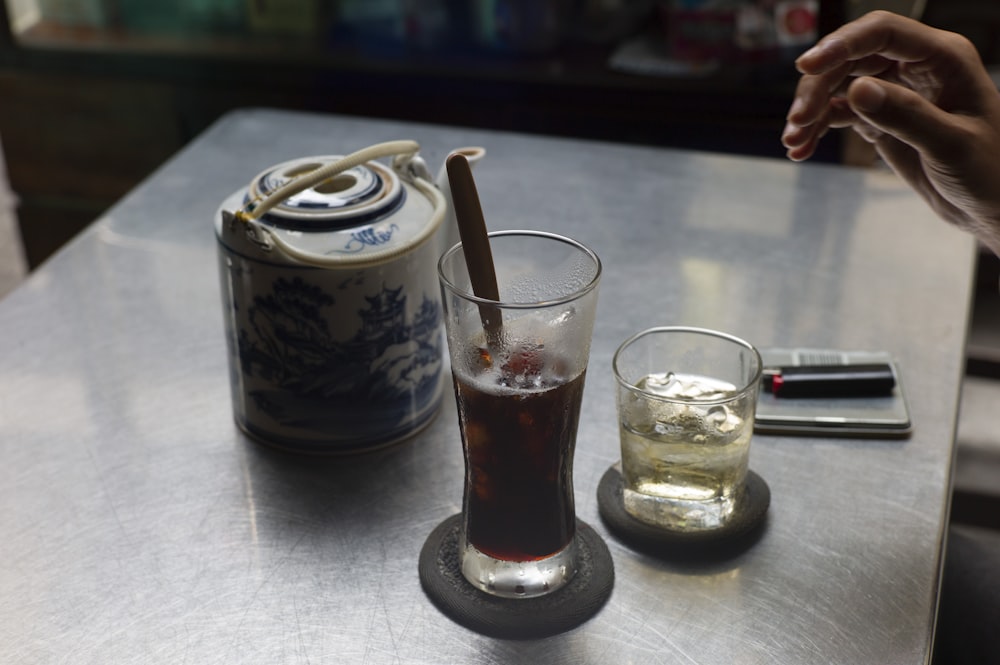 a glass of soda and a can of soda on a table