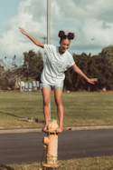 a girl is standing on top of a fire hydrant