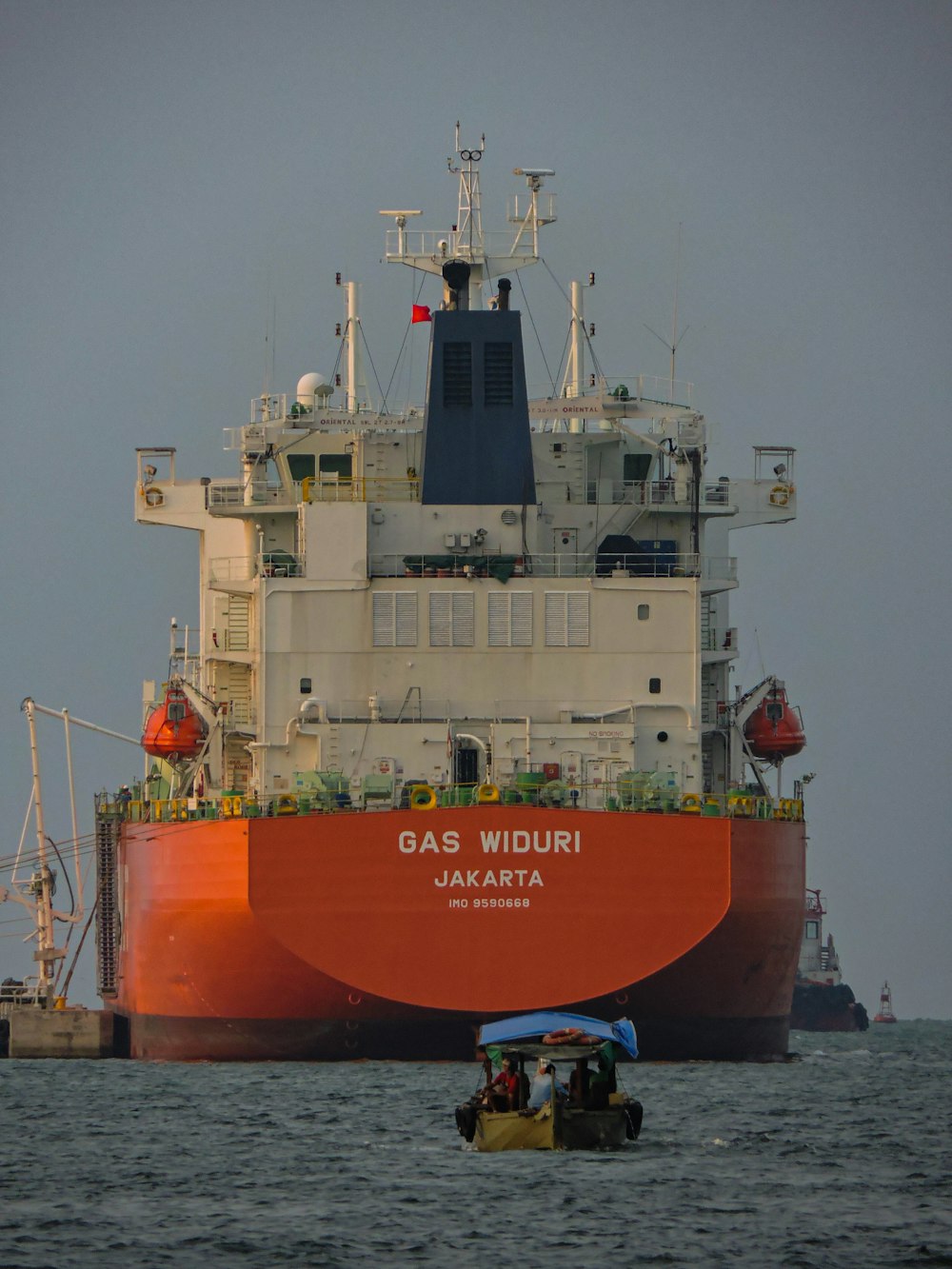 ein großes Boot im Wasser mit einem großen Schiff im Hintergrund