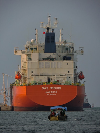 a large boat in the water with a large ship in the background