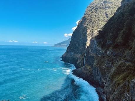 A breathtaking view of Bali's stunning coastline at sunset with lush greenery and vibrant blue waters.