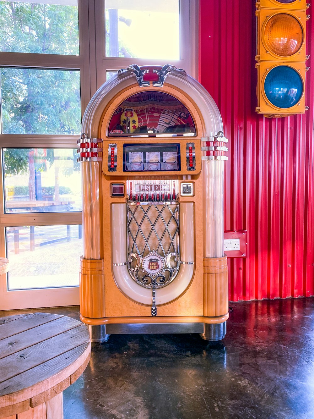 a jukebox sitting in front of a window next to a traffic light