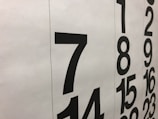 Large black numbers are printed on a white background, arranged in two vertical columns. The numbers appear to be part of a calendar, with bold numerals representing the days.