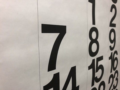 Large black numbers are printed on a white background, arranged in two vertical columns. The numbers appear to be part of a calendar, with bold numerals representing the days.