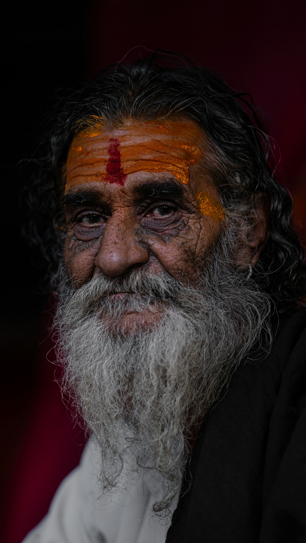 a man with a white beard and a red cross on his forehead