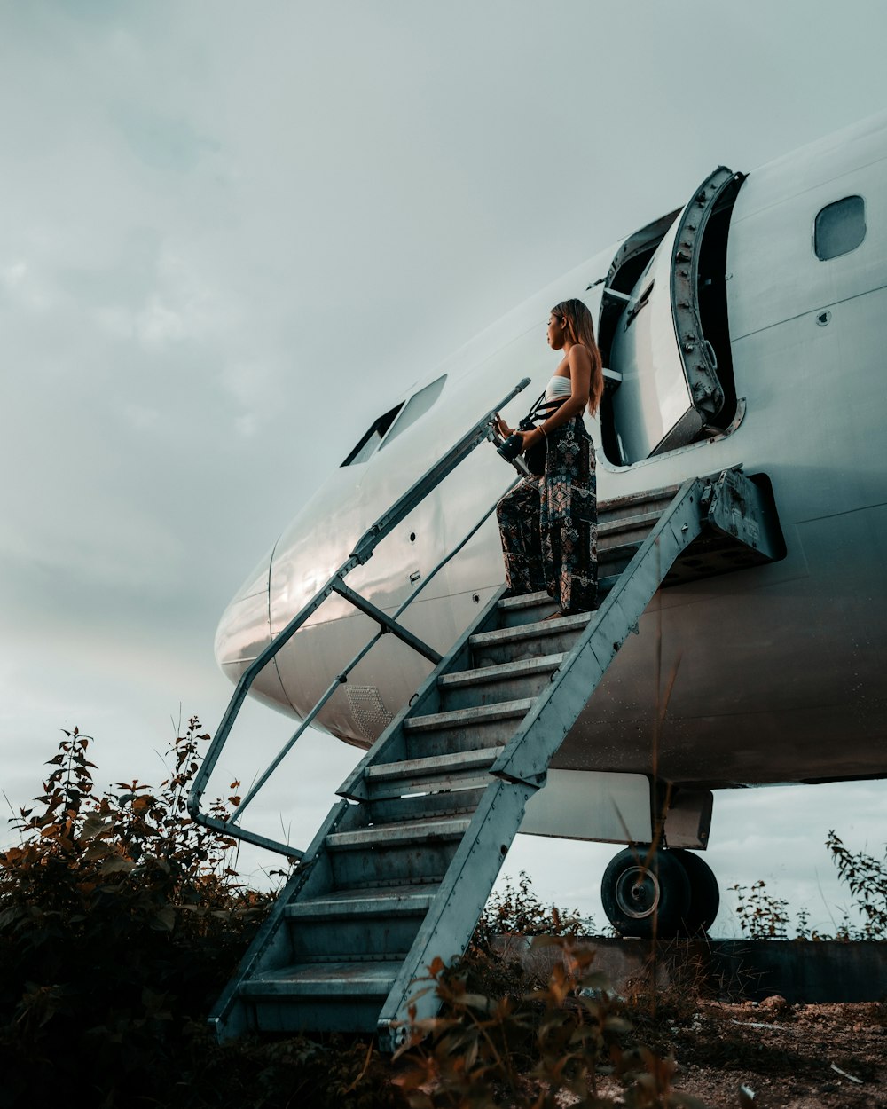 Una mujer parada en los escalones de un avión