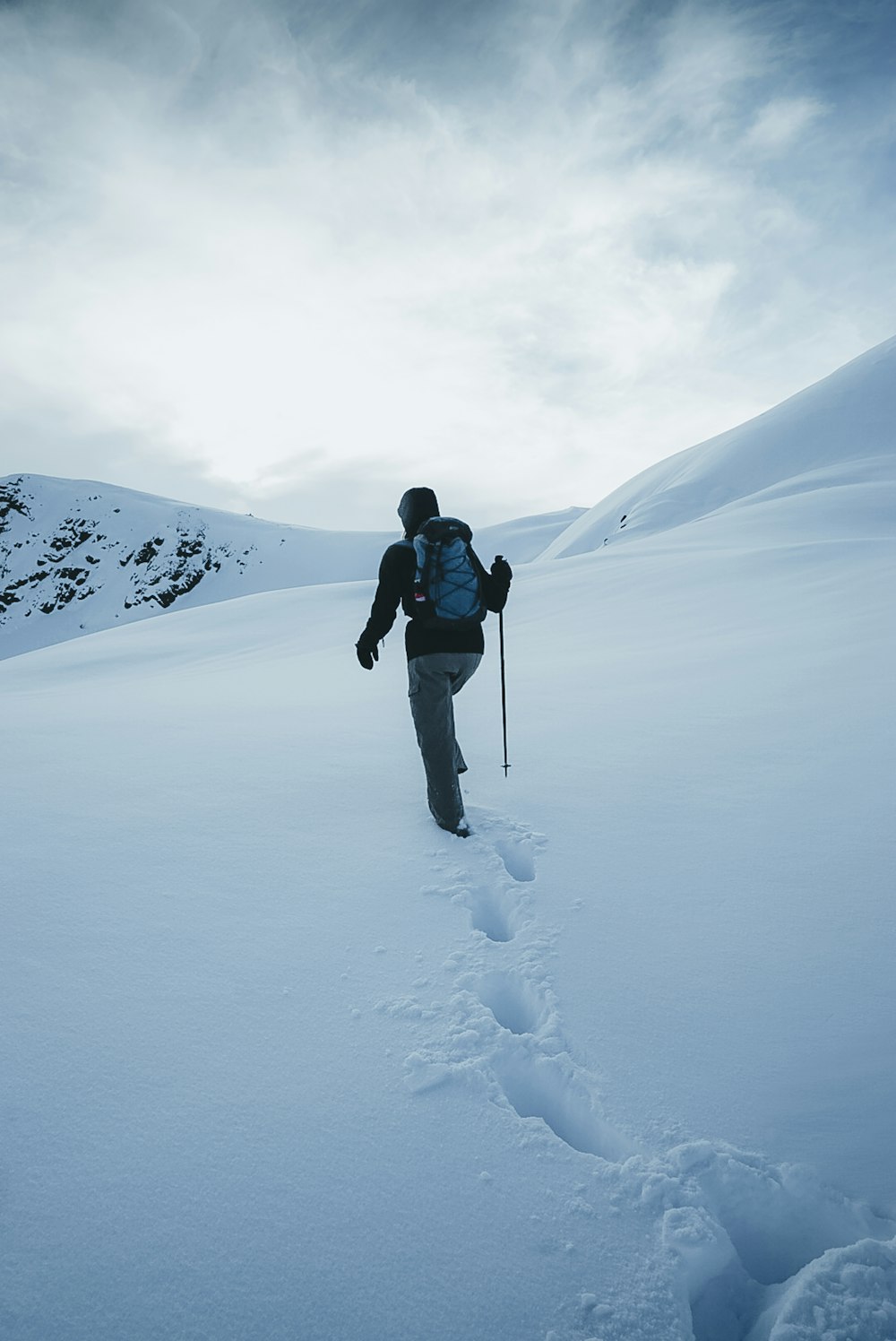 a man walking across a snow covered field