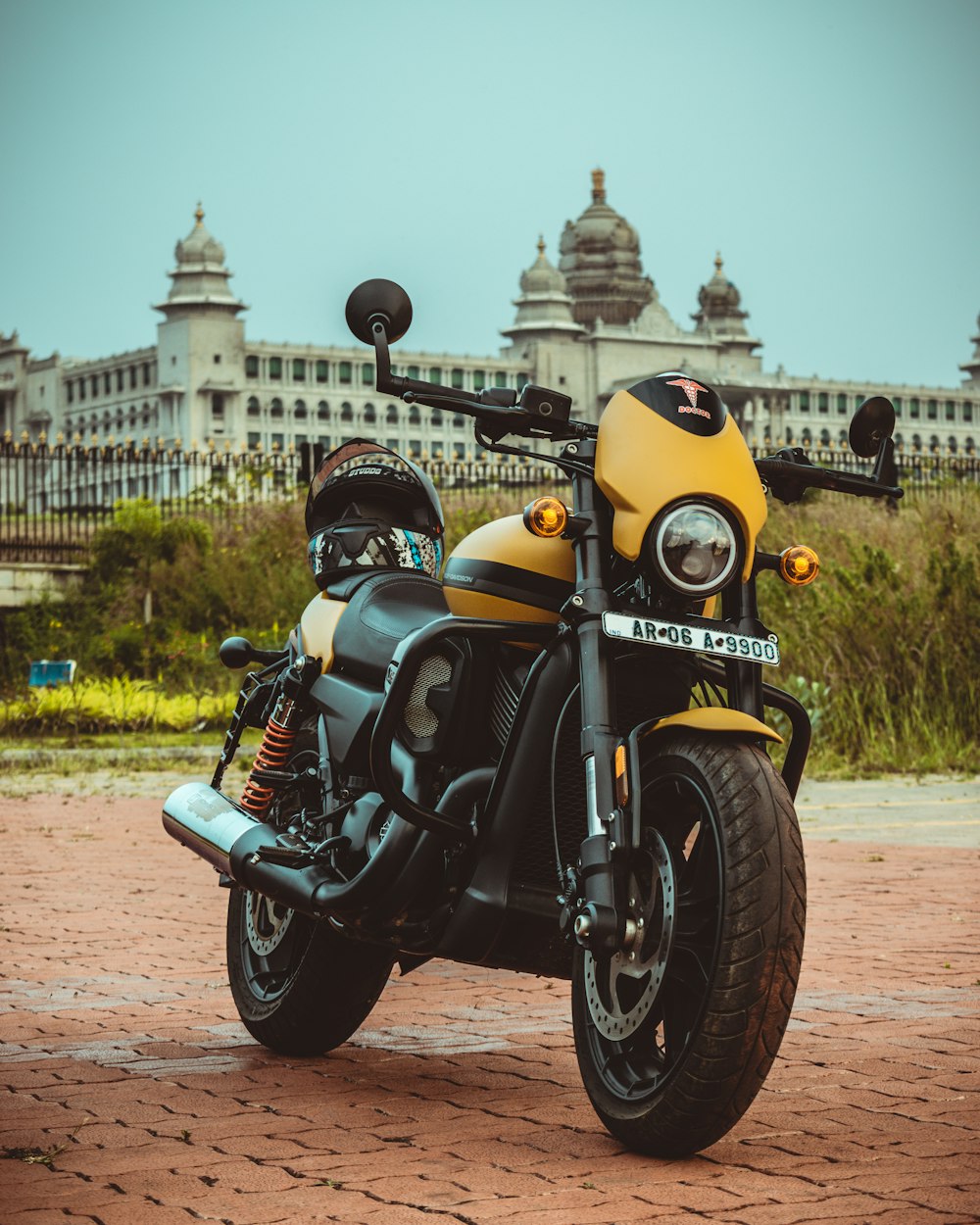 a yellow and black motorcycle parked in front of a building