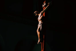 a statue of a man on a cross in the dark