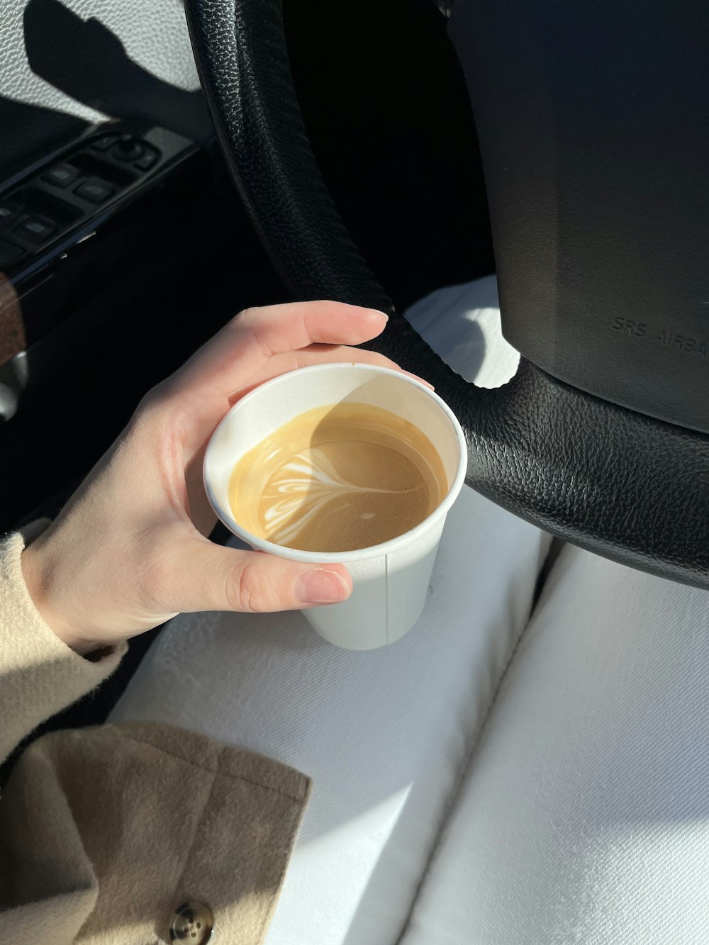 a person holding a cup of coffee in their hand