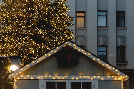 a small white house with christmas lights on the roof