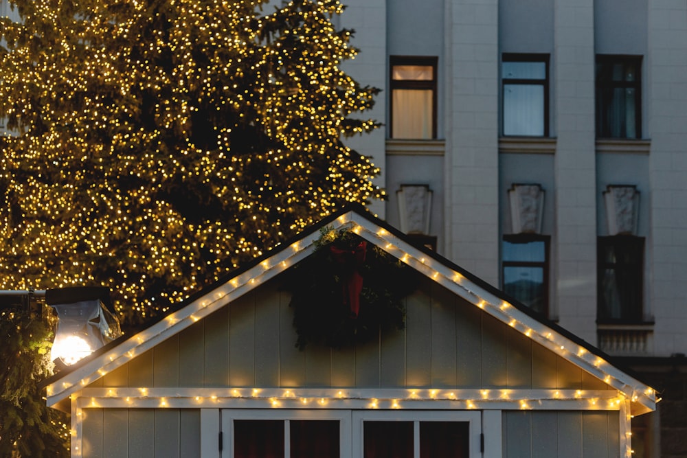 a small white house with christmas lights on the roof