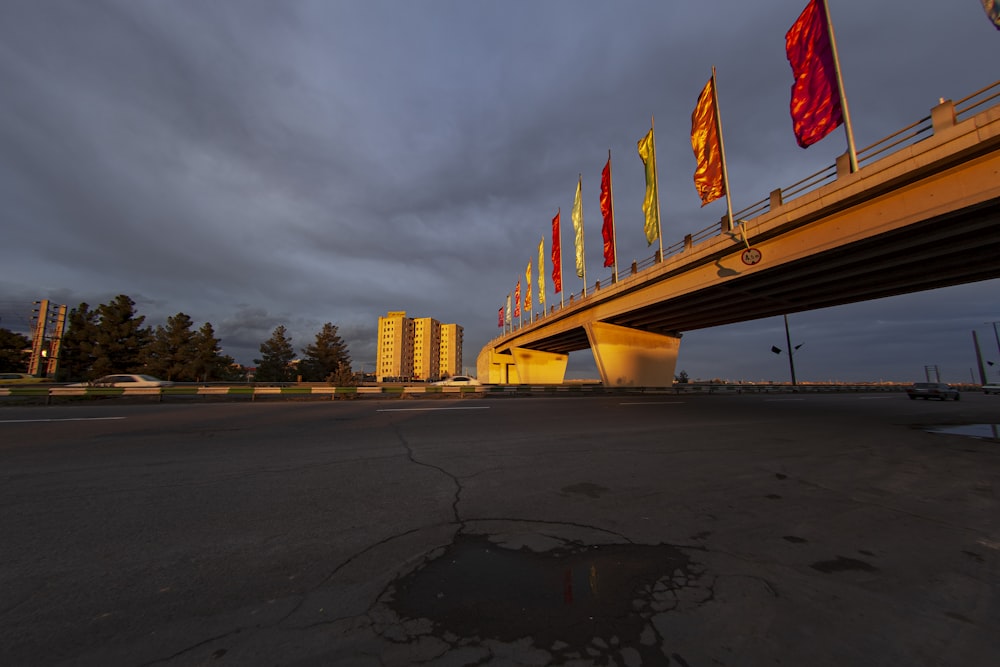 a bridge over a road with flags on it