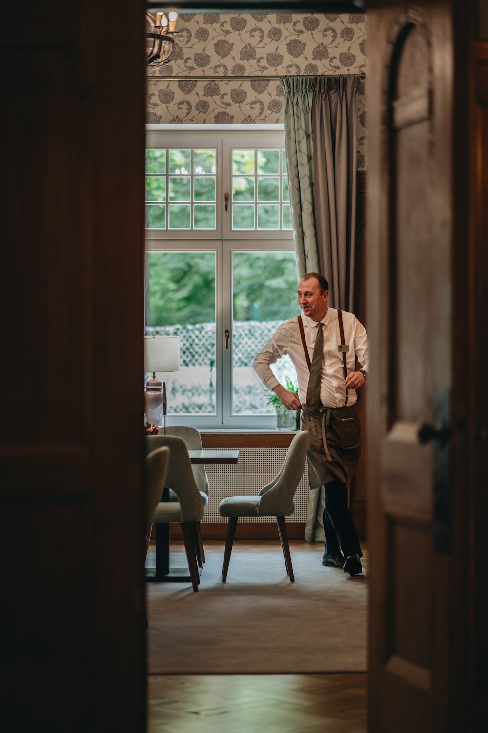 a man standing in front of a window in a living room