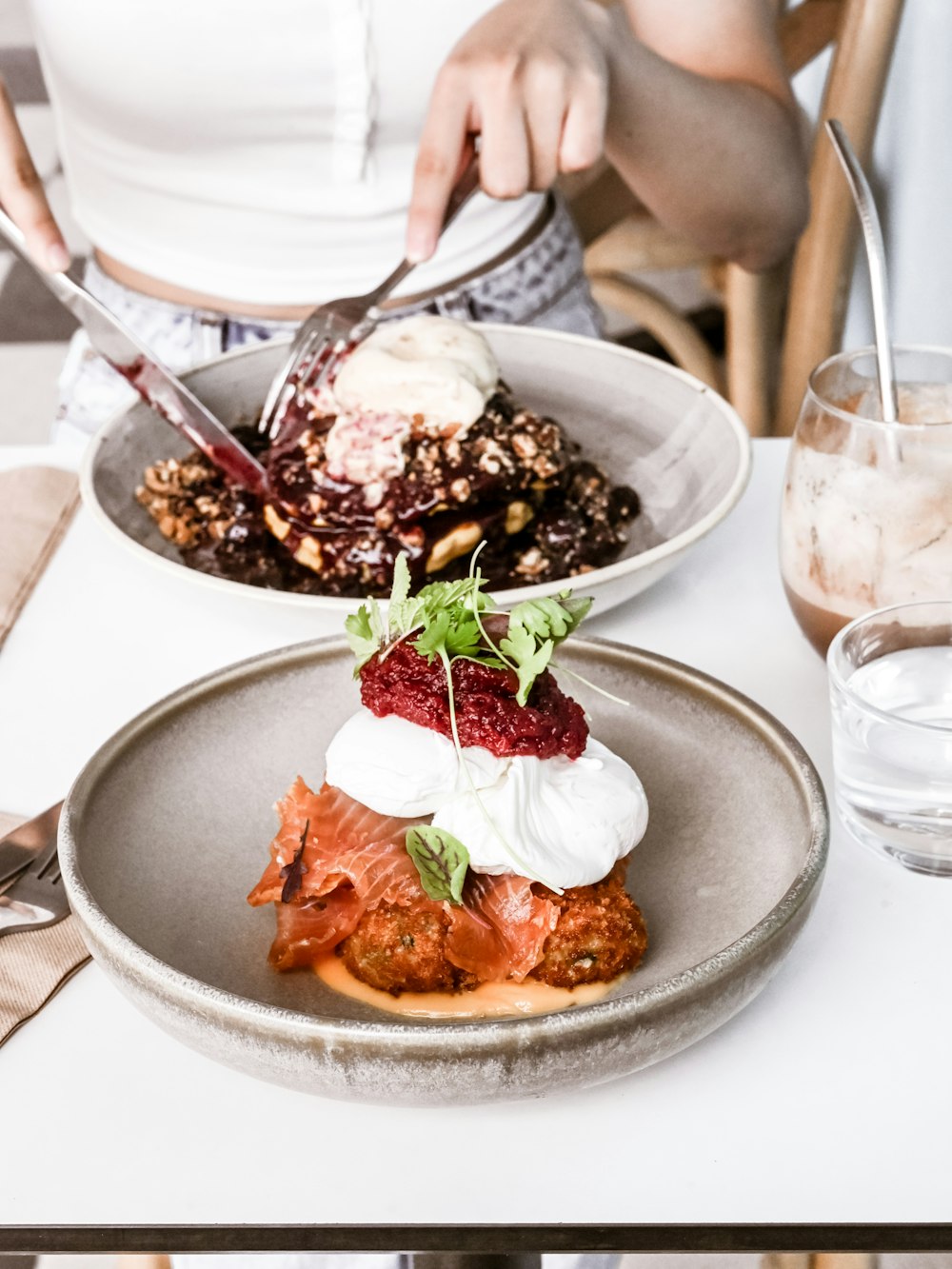 a woman is cutting into a dessert on a plate