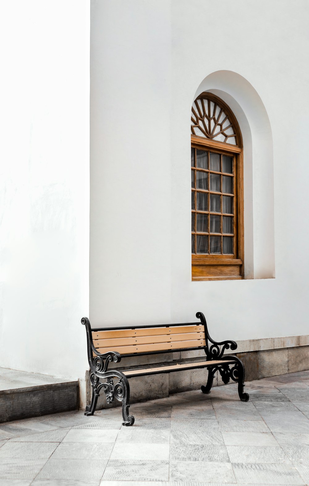 a wooden bench sitting in front of a window