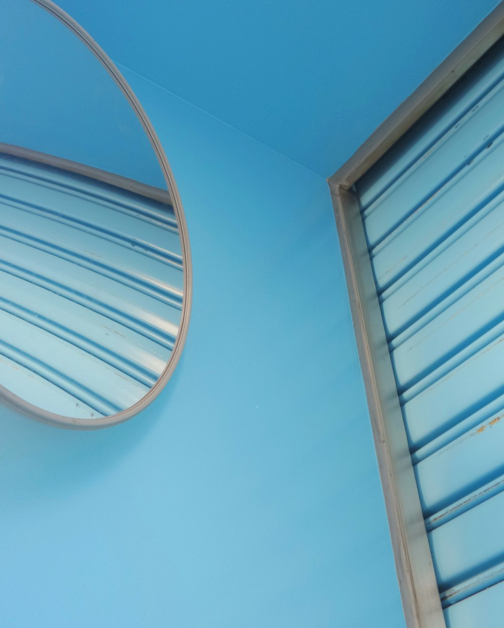 a round mirror hanging on the side of a wall