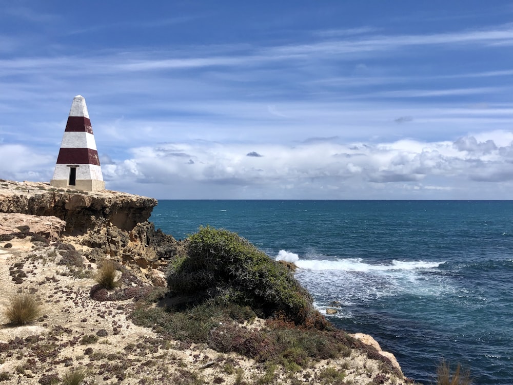 a lighthouse on a cliff overlooking the ocean