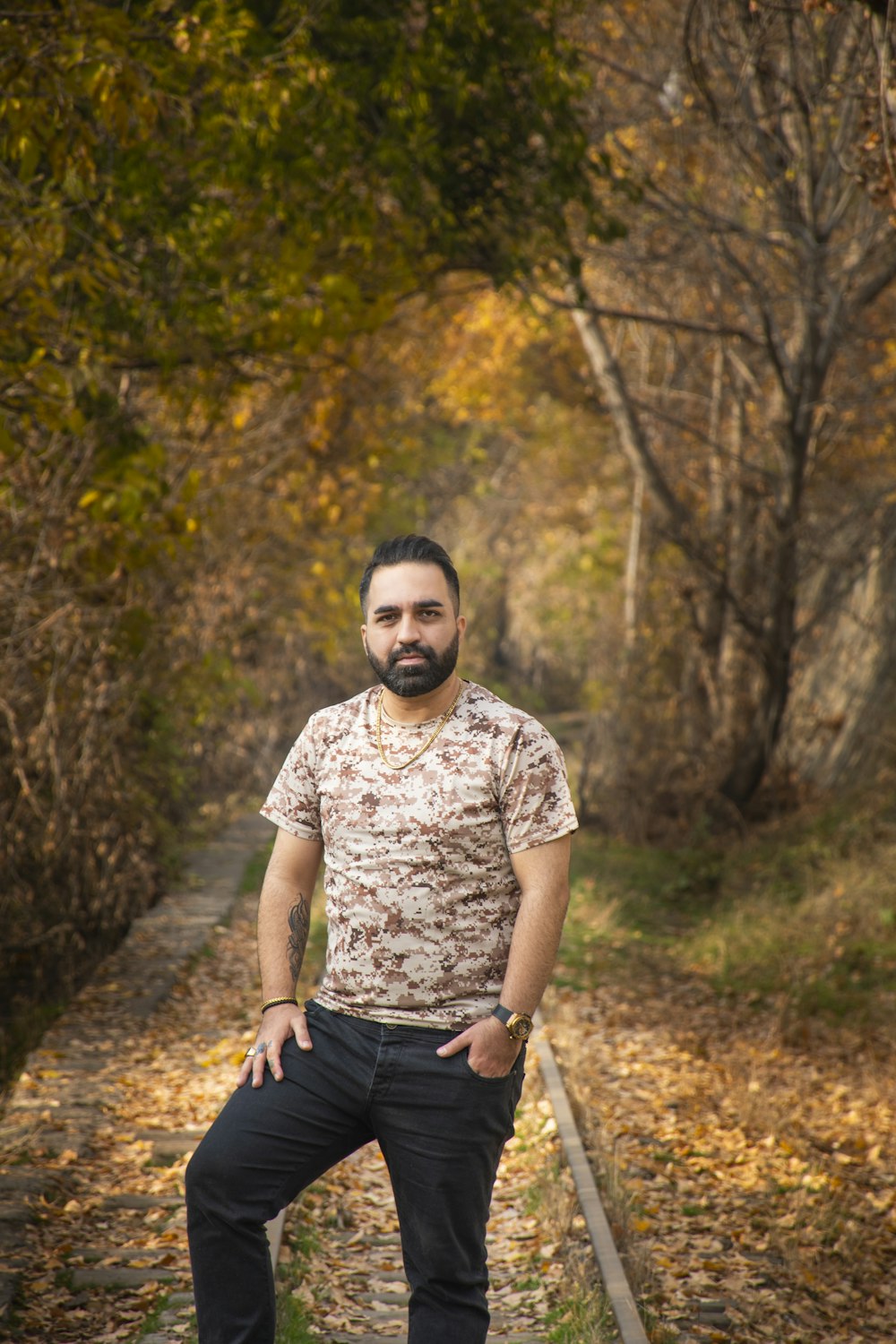 a man standing on a train track in the woods