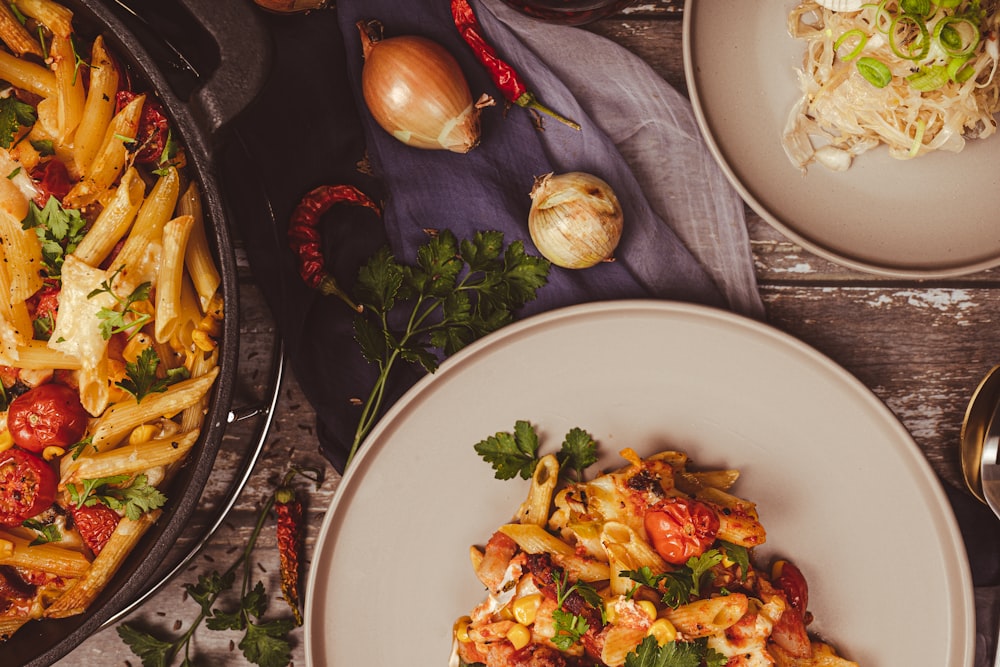 une table garnie d’assiettes de pâtes et de légumes