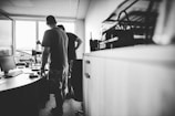 a man standing in front of a desk with a computer on it