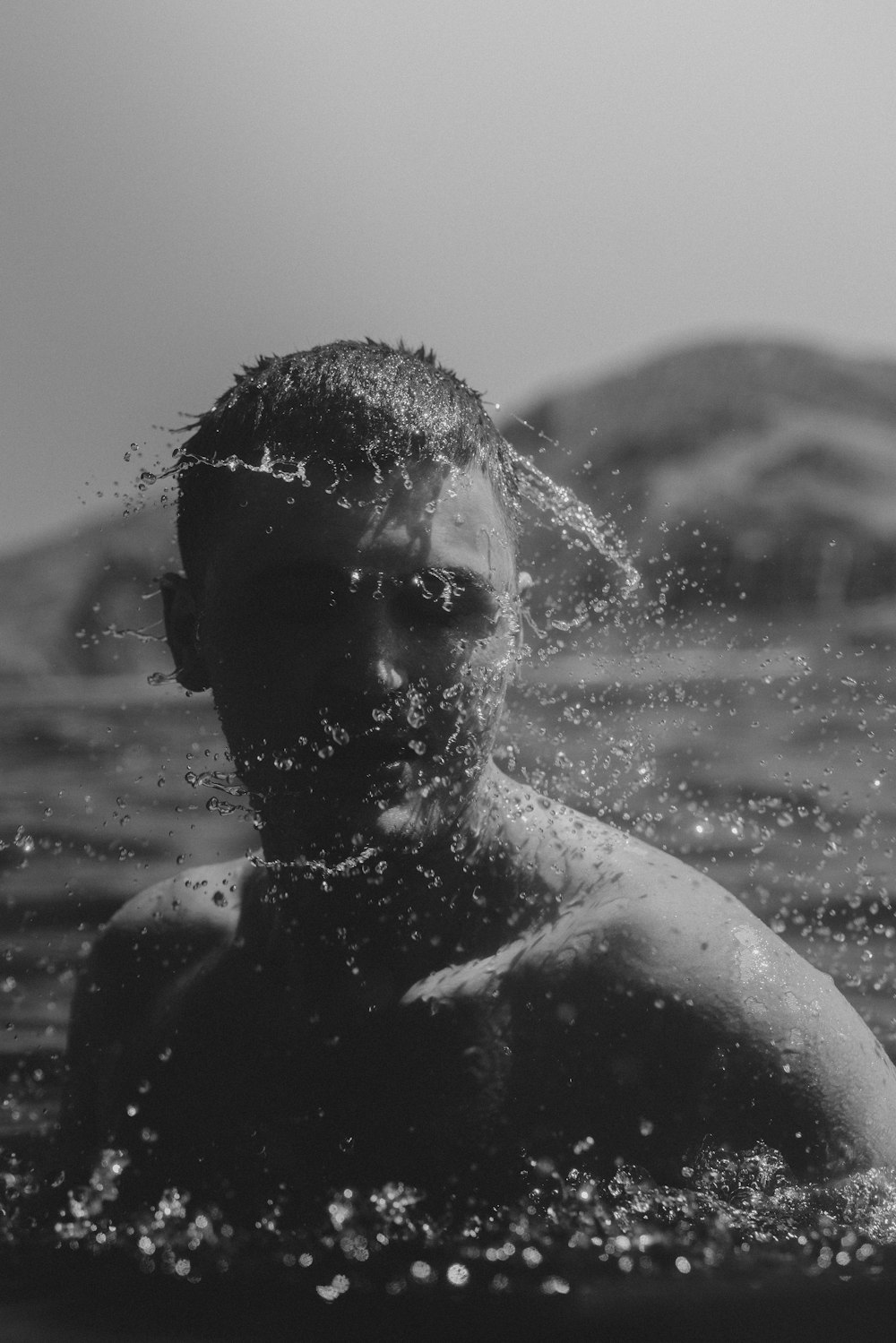 a black and white photo of a man in the water