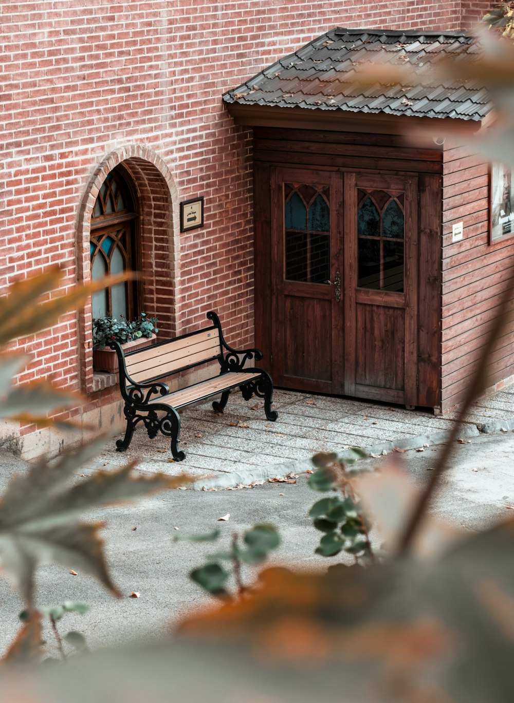 a wooden bench sitting in front of a brick building