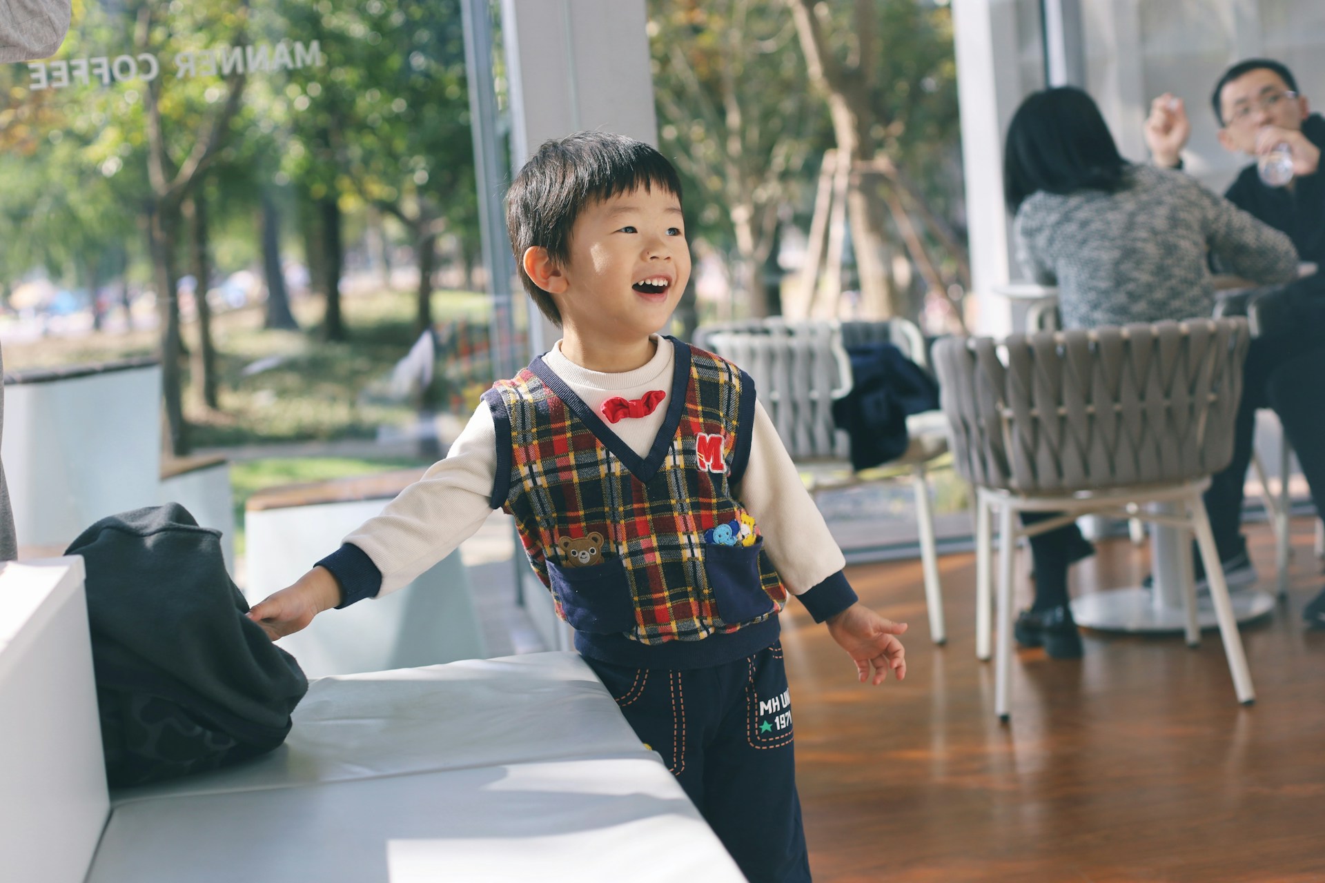 Playful kids laughing at the VeggieNest Cafe’s family-friendly seating area filled with natural light and cheerful decor.