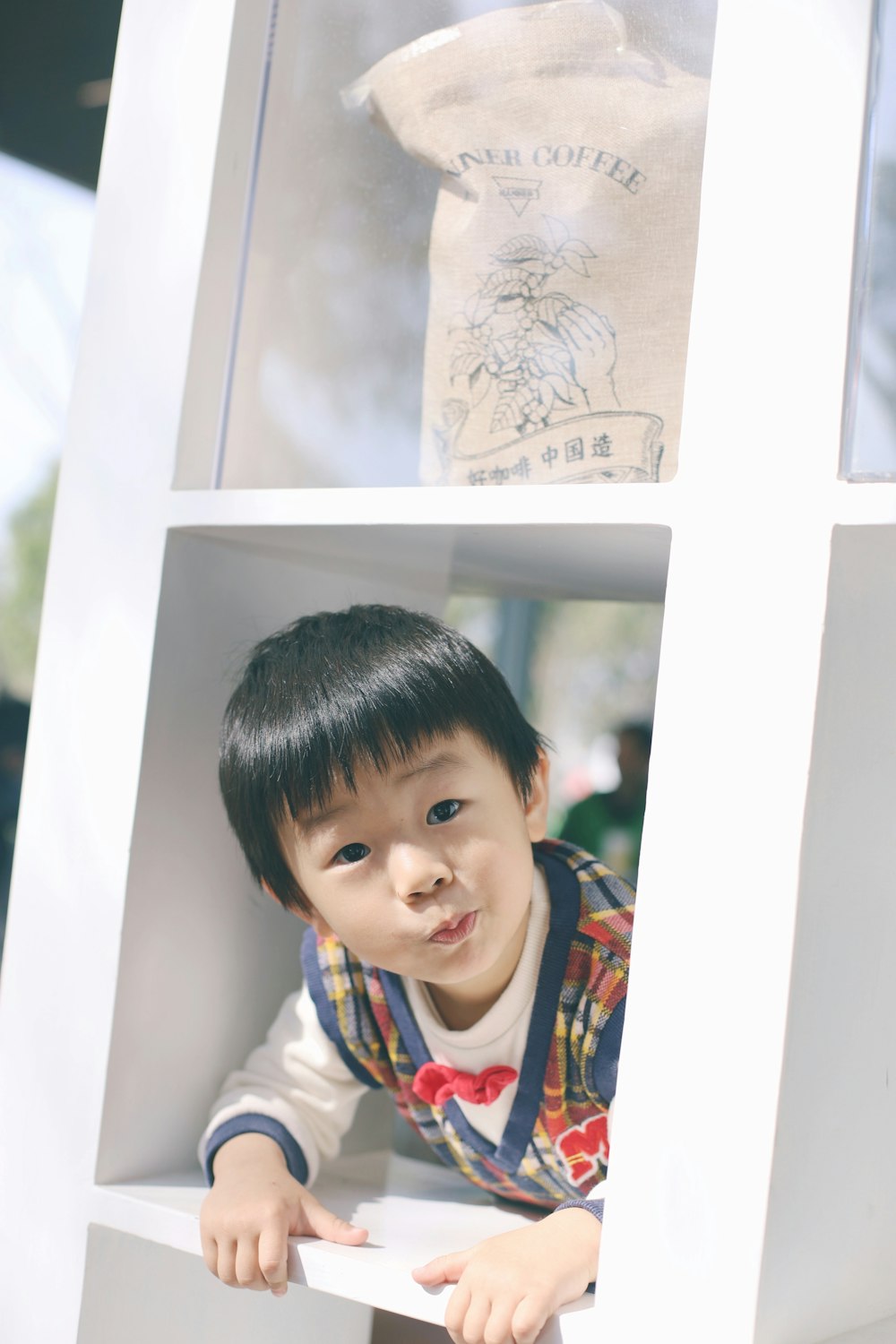 a small child is peeking out of a window