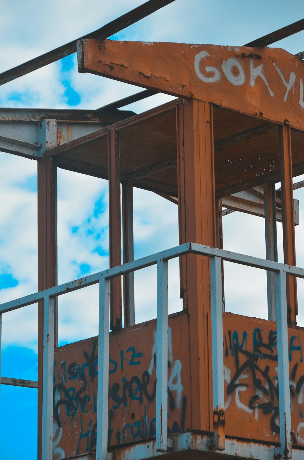 a rusted metal structure with graffiti on it