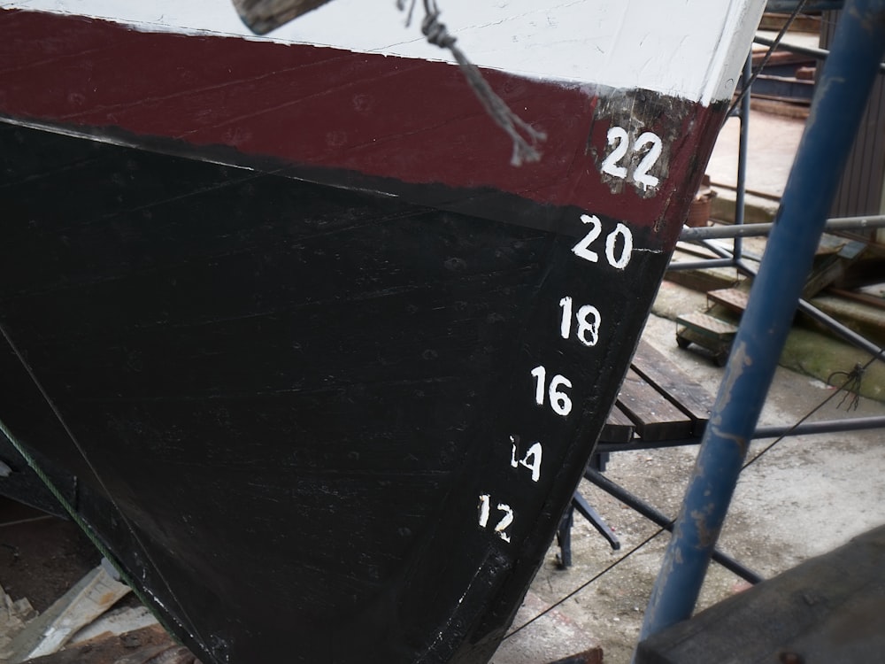 a black and white boat sitting on top of a wooden floor