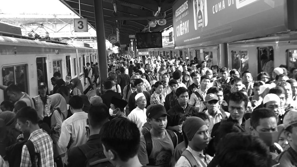 a large group of people waiting for a train