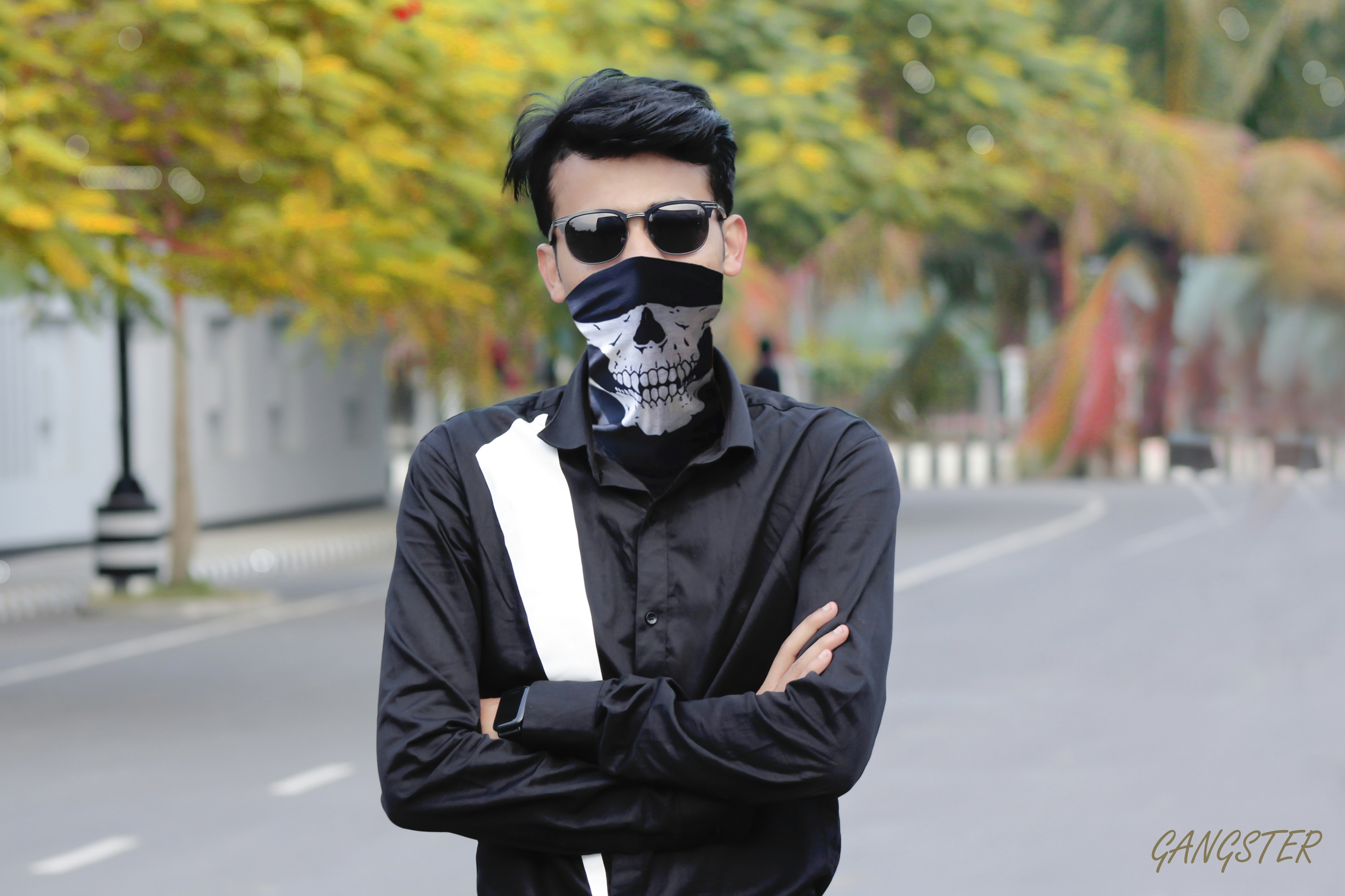 Seorang pria berbaju hitam dengan topeng tengkorak di wajahnya