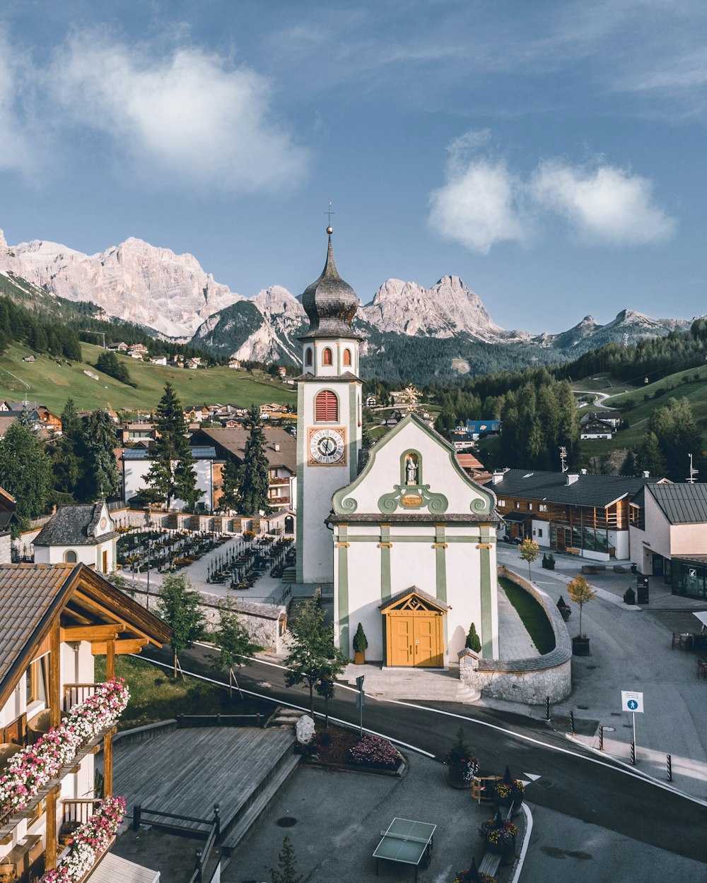 uma pequena cidade com uma igreja e montanhas ao fundo