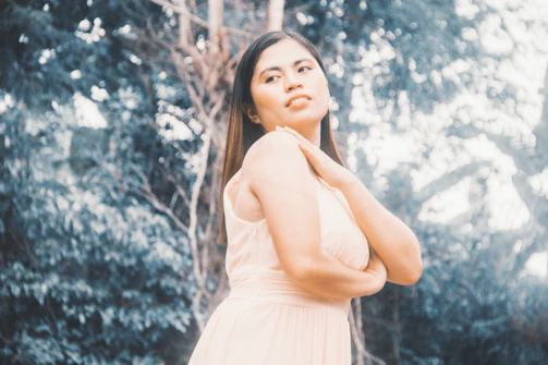 A serene outdoor shot of a model wearing a flowing boho maxi dress in soft earth tones, surrounded by natural greenery.