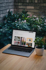 a laptop computer sitting on top of a wooden table