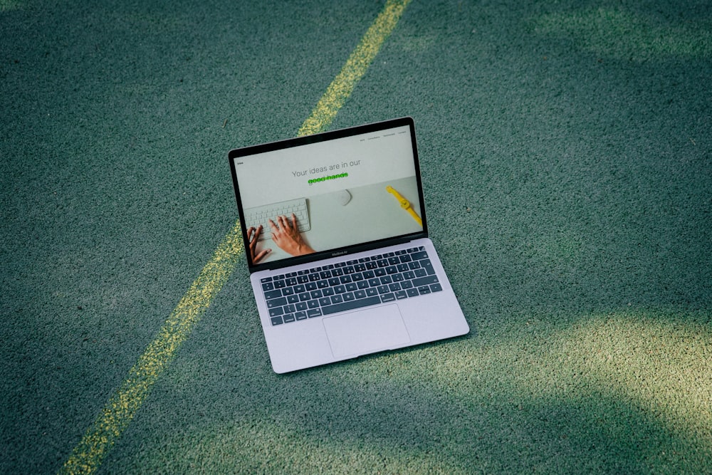 a laptop computer sitting on top of a tennis court