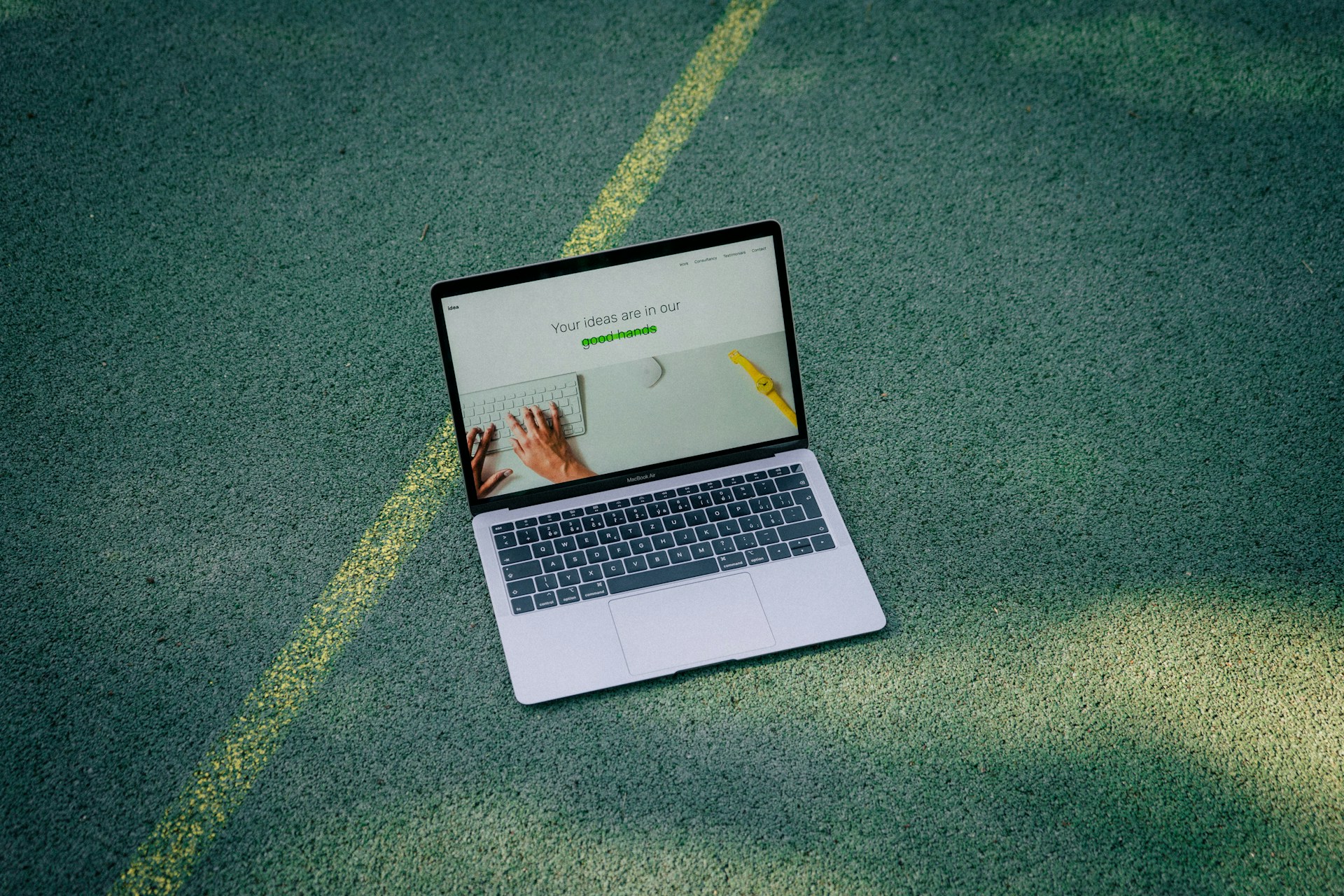 a laptop computer sitting on top of a tennis court
