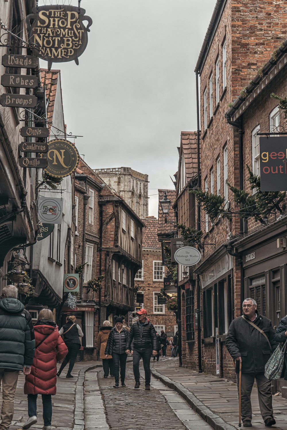 a group of people walking down a street next to tall buildings