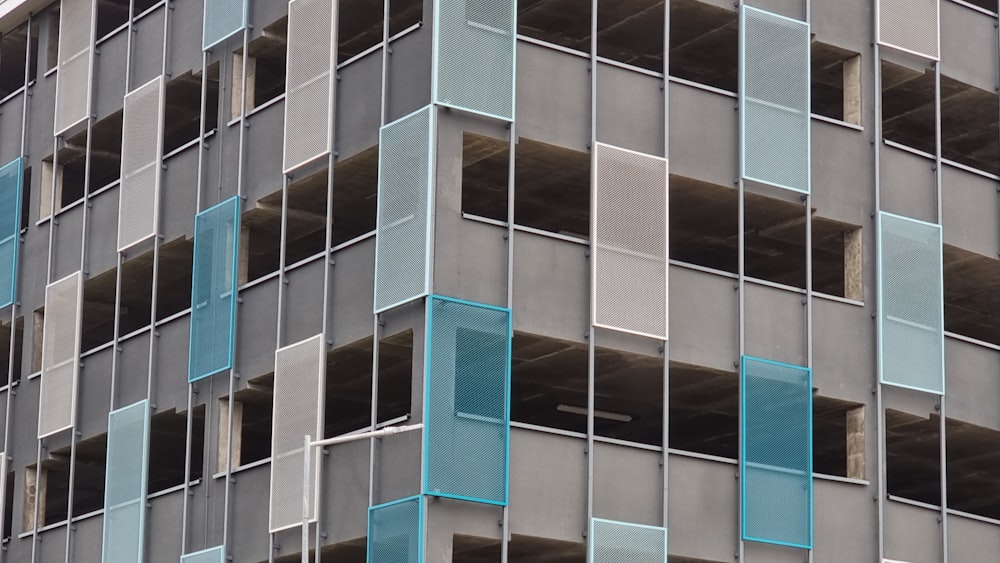 a tall building with lots of windows and blue shutters