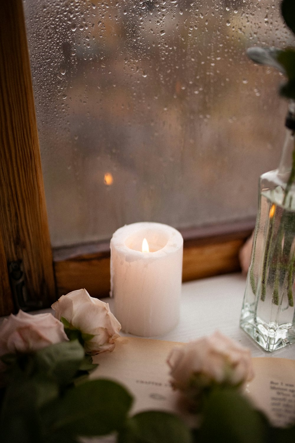 a candle and some flowers on a window sill